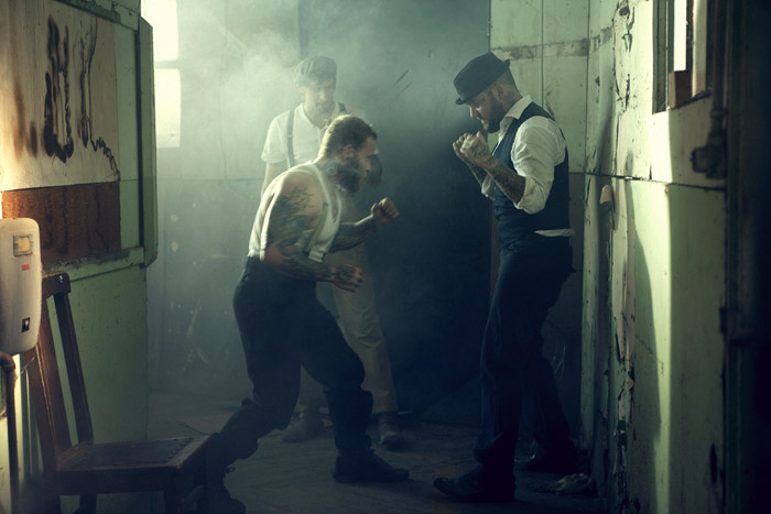 Two men squaring up to fight in a smoky hallway