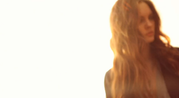 Backlit portrait of the model against a bright sky