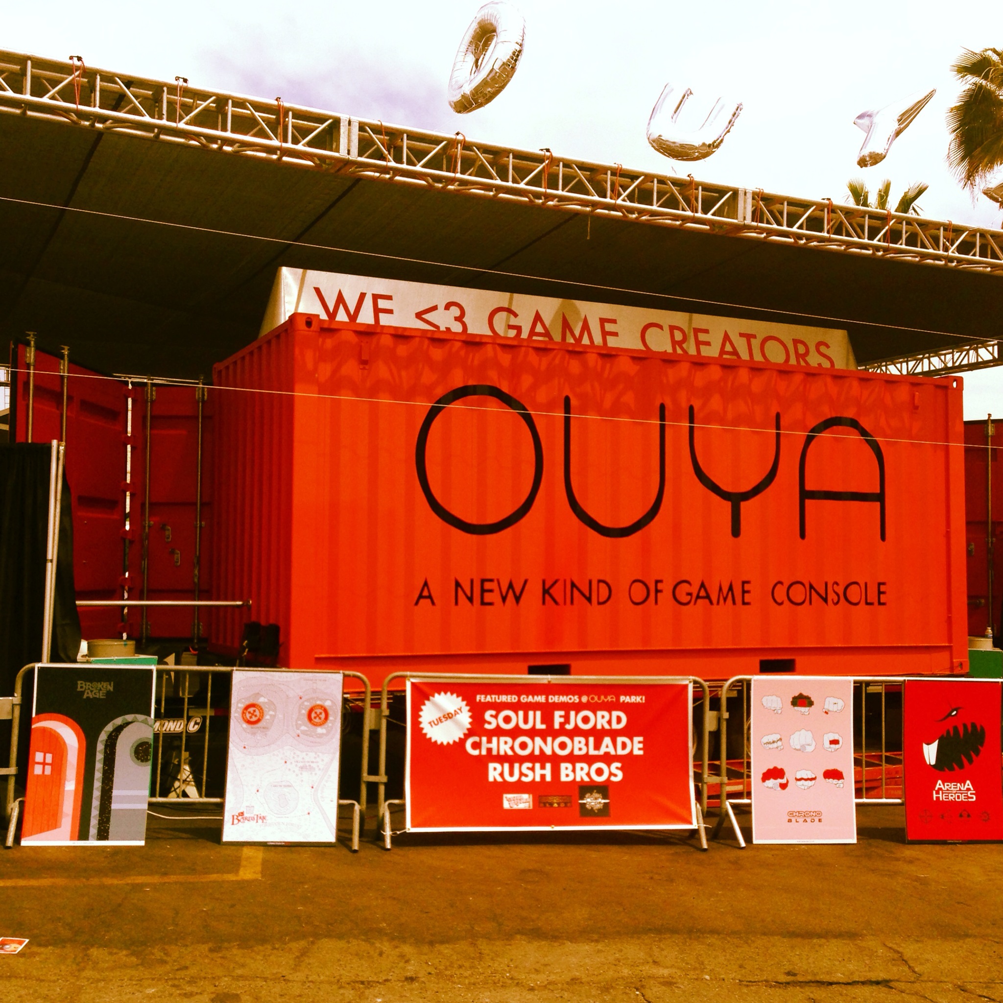 OUYA outdoor event space at E3, with an orange wall and game kiosks