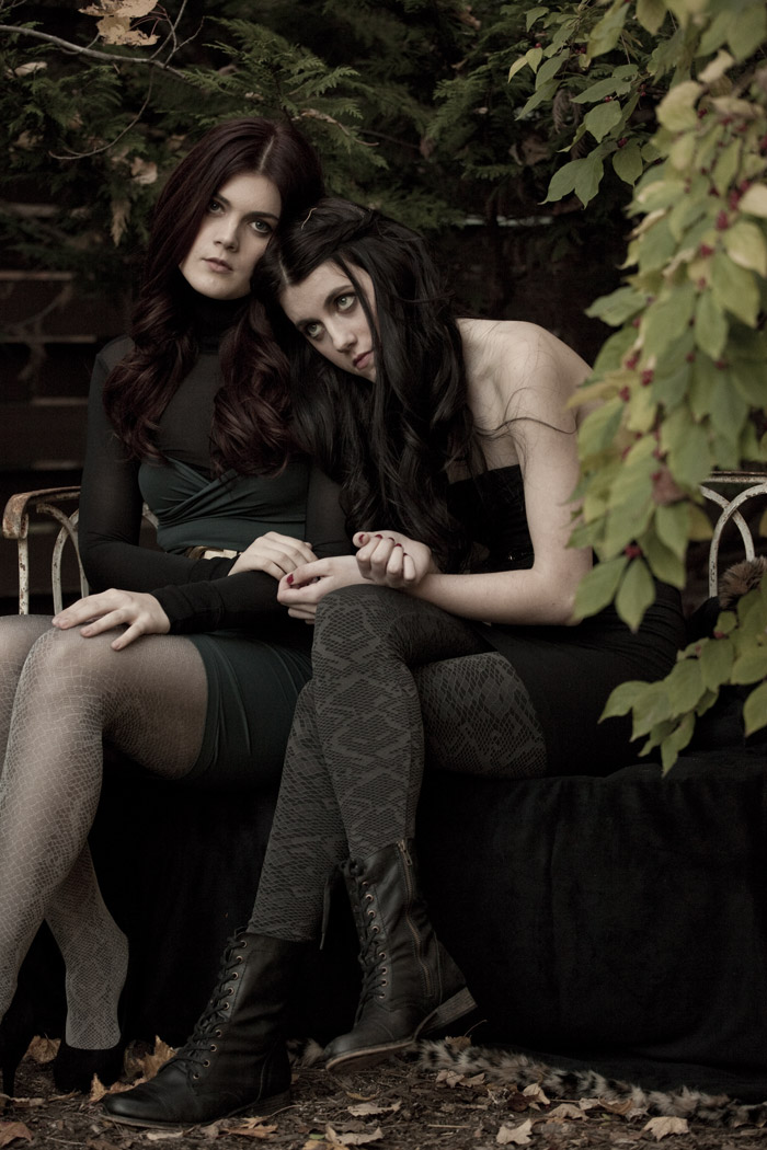 Two models on a garden bench in patterned tights